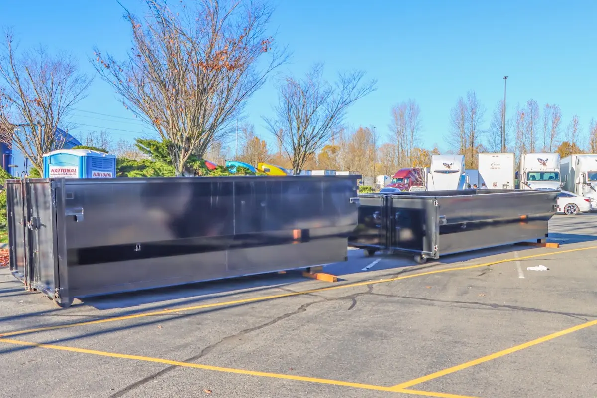 Professional dumpster rental service with roll-off container on residential driveway in Natchez